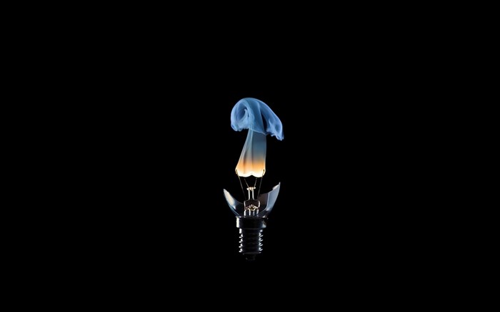 Broken light bulb with smoke and flame