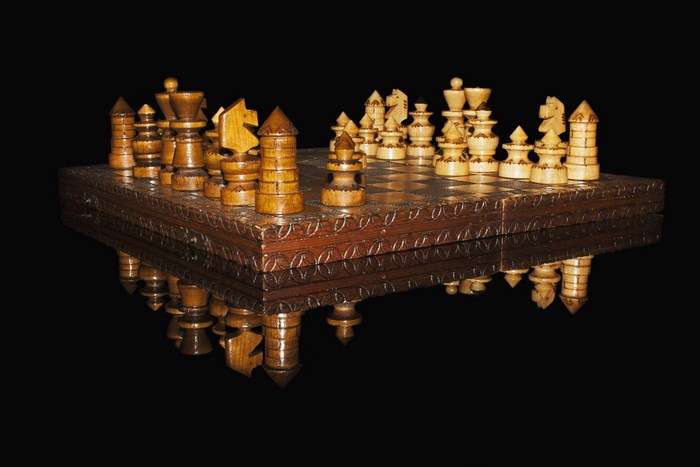 Wooden chess set on a reflective surface