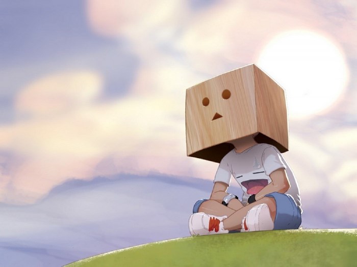 Person with a box on head sitting on a hill