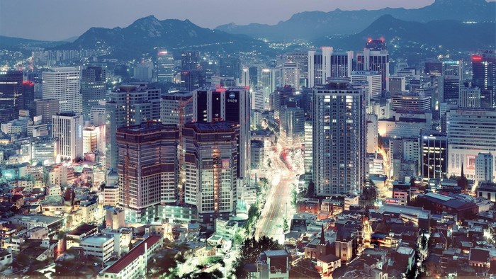 Seoul cityscape at dusk with mountains in background