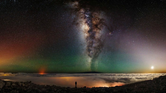 Milky Way over clouds with lone figure