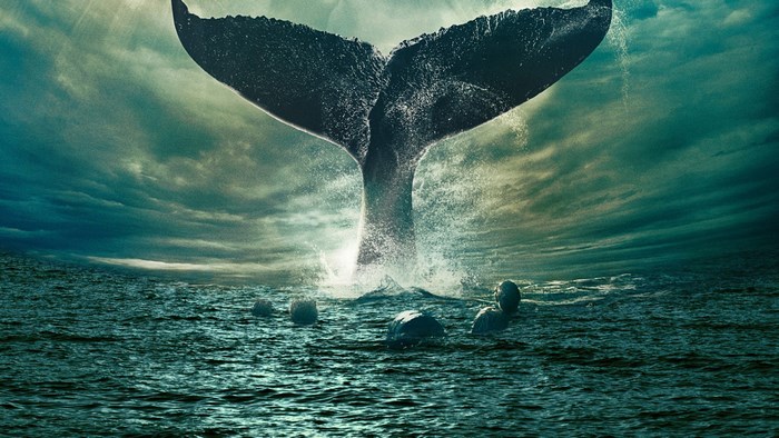 Whale tail emerging from the ocean with people in the water
