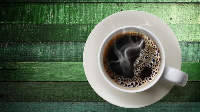 4K Coffee Cup on Green Wooden Table