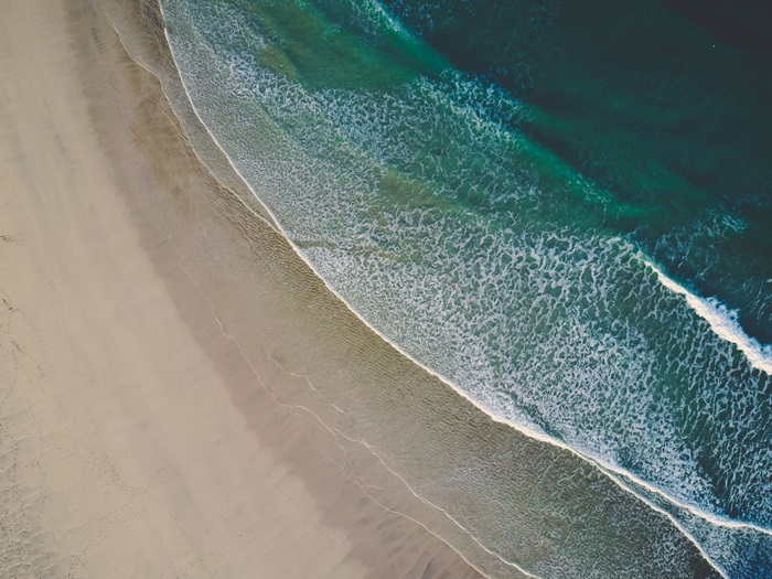 Aerial view of a sandy beach and ocean waves