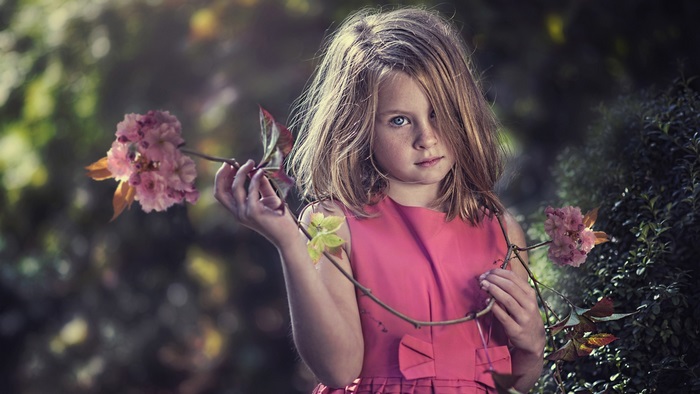 Young girl in pink dress holding flowers