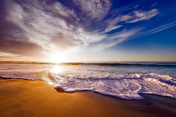 Sunset over the ocean with waves on the beach