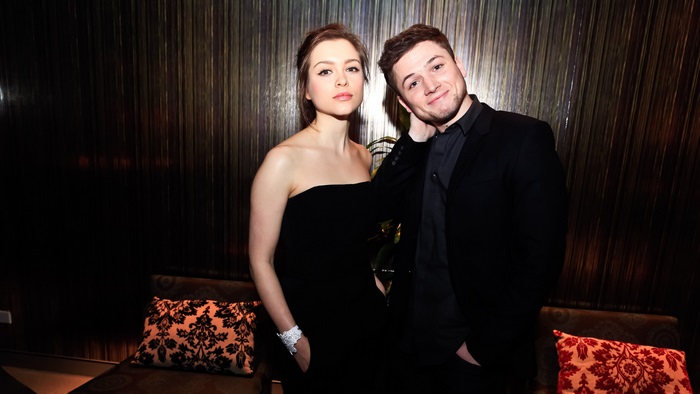 Taron Egerton and actress in black dress