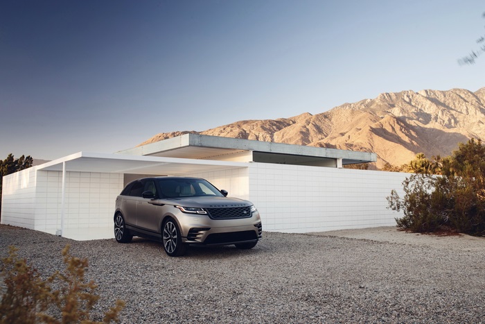 Range Rover Velar parked by modern house and mountains