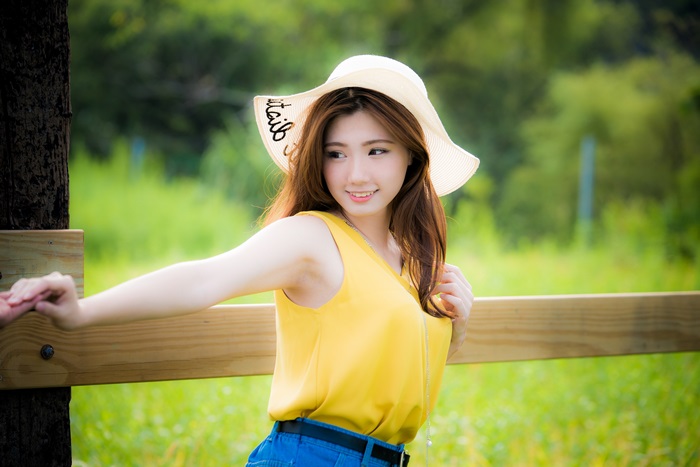 Young Woman in Yellow Top with Sun Hat Outdoors