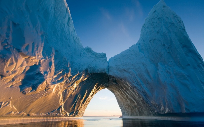 Iceberg arch with sunlight and blue sky