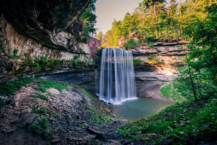 Waterfall with red buildings and trees