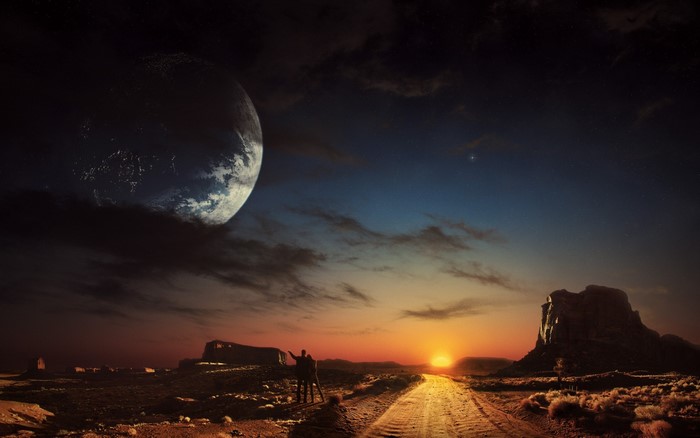 Two figures stand on a dirt road looking at a planet and sunset