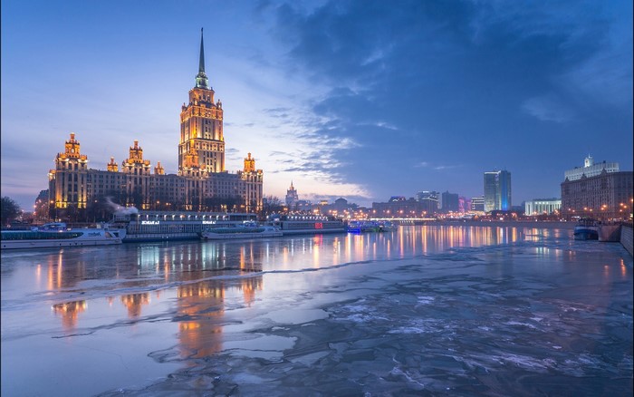 Moscow skyline with frozen river at dusk