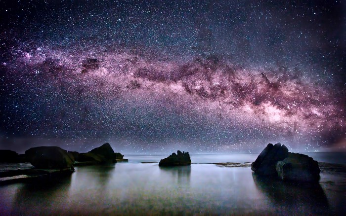 Milky Way galaxy over ocean rocks