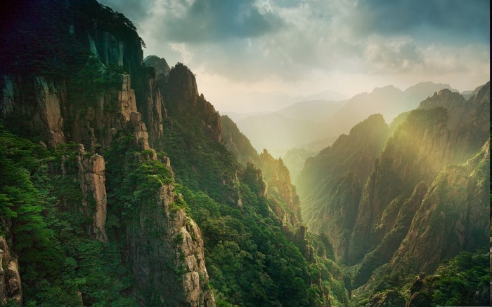 Mountain canyon with sun rays and clouds