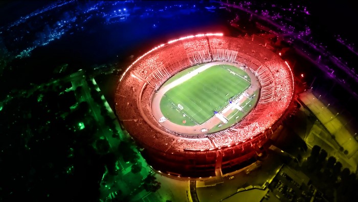 Aerial view of River Plate stadium at night with colorful lights