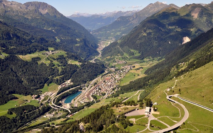 Aerial view of a valley town in the Swiss Alps with mountains and roads