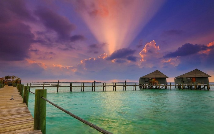 Sunset Overwater Bungalows and Vibrant Sea in Maldives