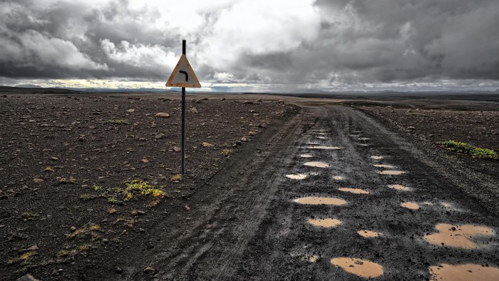 Road sign on a muddy road in a desolate landscape