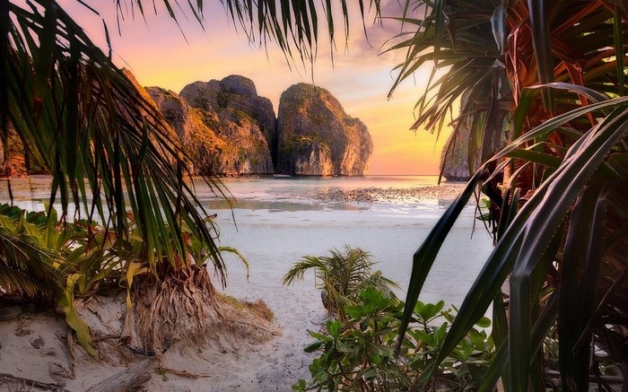 Tropical beach with limestone cliffs at sunset
