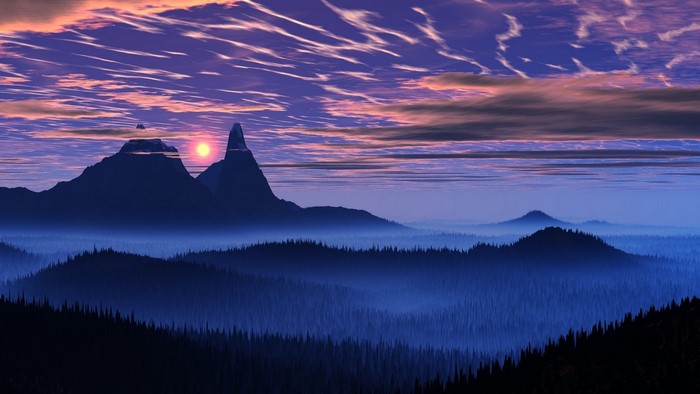 Misty mountain valley at sunset with purple clouds