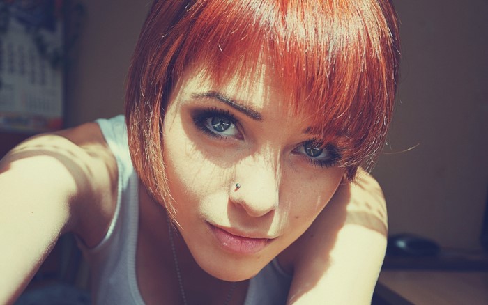 Redhead woman with short hair and nose piercing