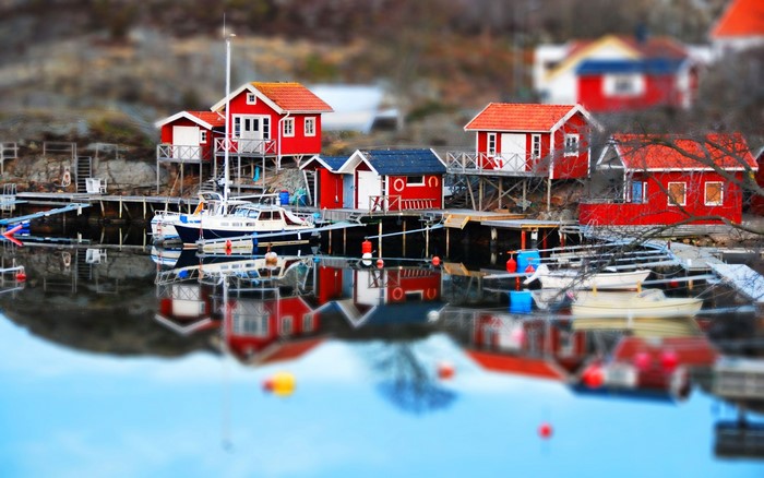 Tilt shift dock with red houses and boats in Sweden