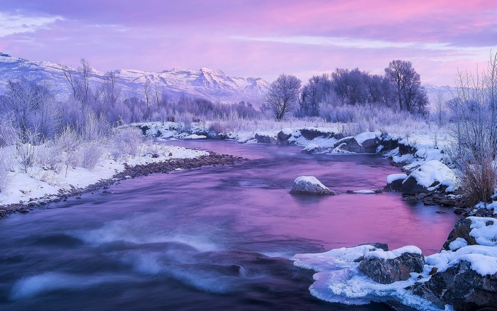 Winter River Flowing Through Snowy Mountains at Twilight