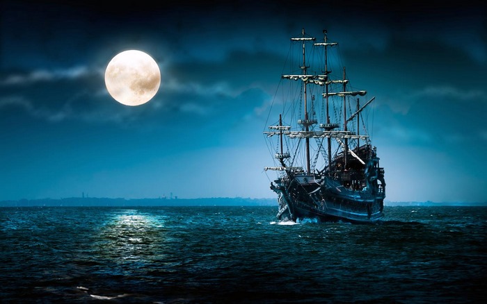 Pirate ship sailing on the ocean under a full moon