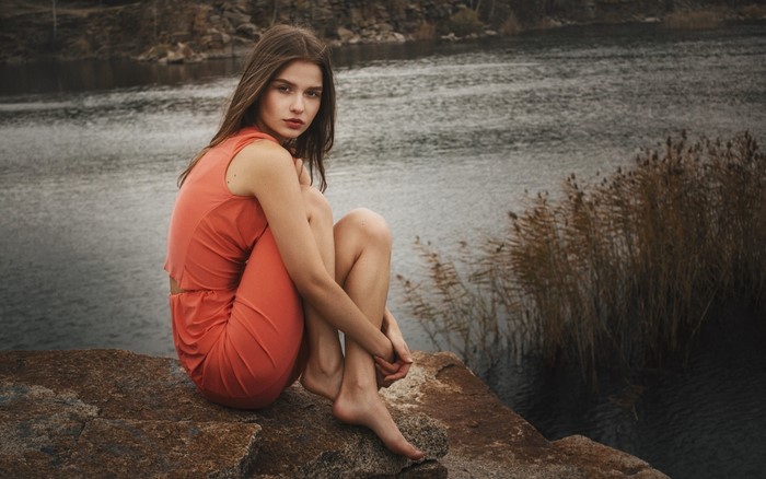 Woman sitting by a river