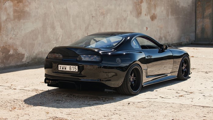 Sleek Black Toyota Supra MK4 on Sunlit Concrete