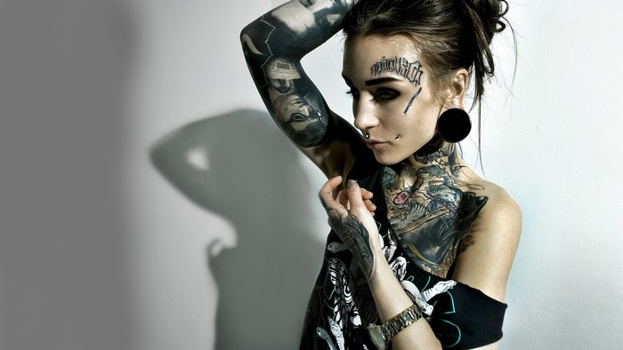 Woman with extensive tattoos and piercings