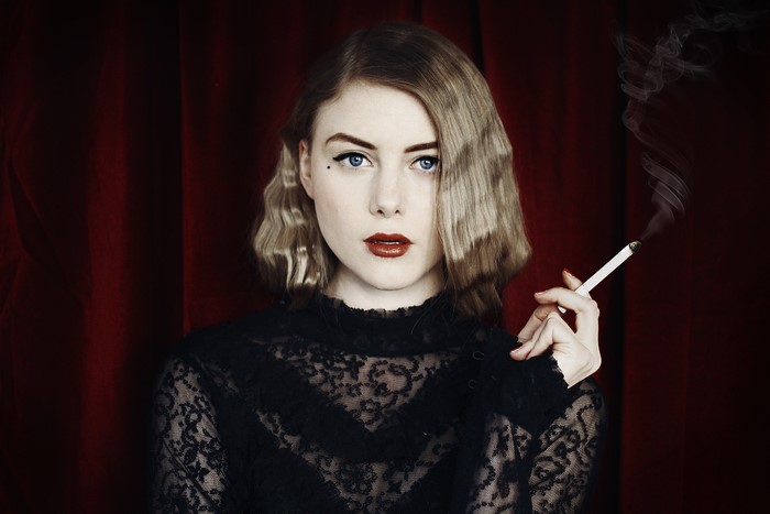 Woman with wavy hair smoking a cigarette