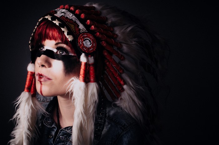 Woman wearing a Native American headdress and face paint