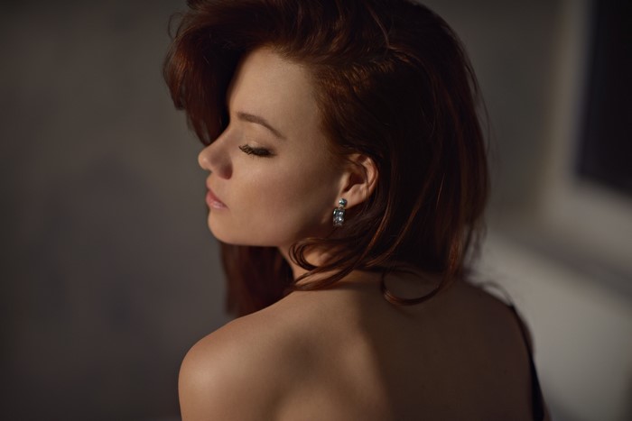 Redhead woman with closed eyes and bare shoulders