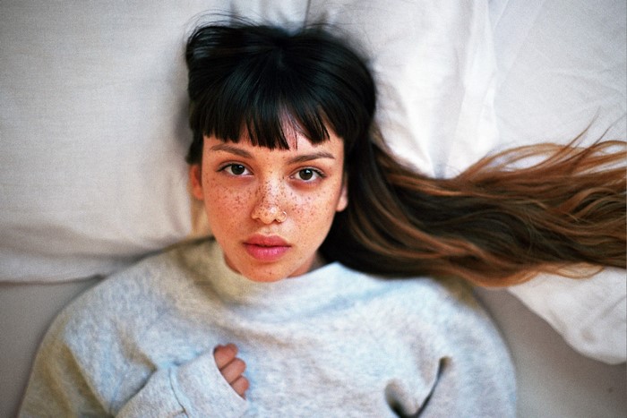 Woman with freckles lying in bed