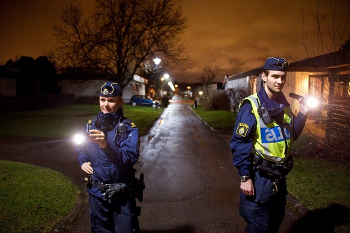 Two Swedish police officers on patrol at night