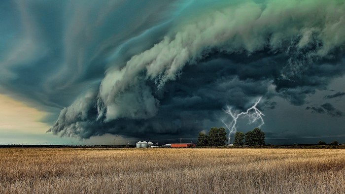 Supercell storm with lightning over a farm field