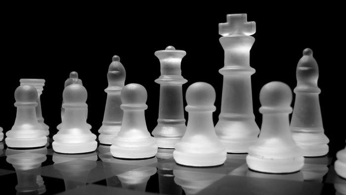 Glass chess pieces on a black background