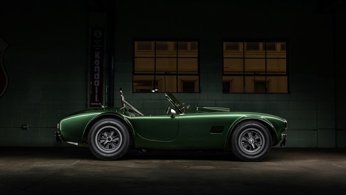 Green Shelby Cobra car in a garage