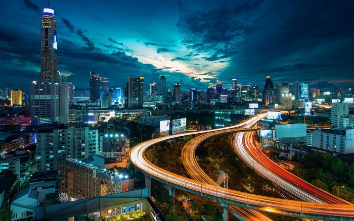 Bangkok cityscape at night with light trails on highway