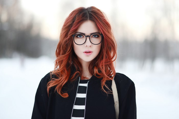 Woman with red hair and glasses in the snow