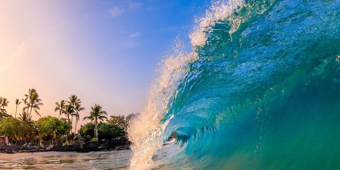 Ocean wave crashing on a tropical beach at sunrise
