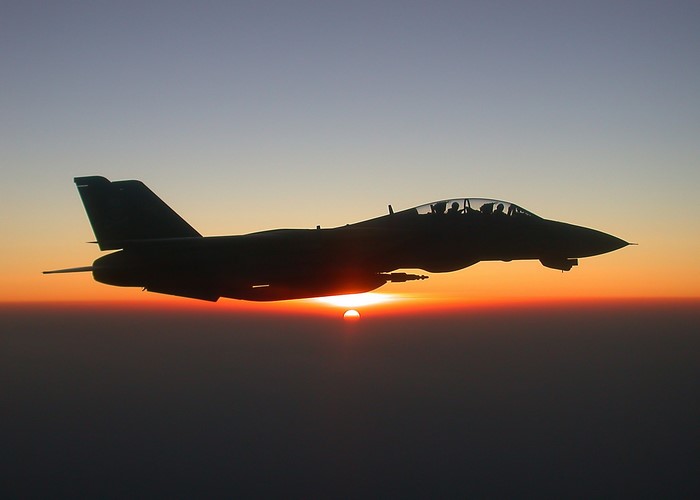 F-14 Tomcat airplane flying at sunset