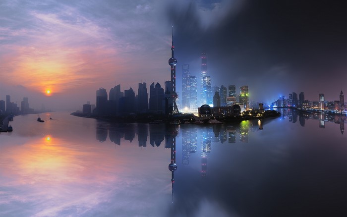 Shanghai skyline at sunset and night with river reflection