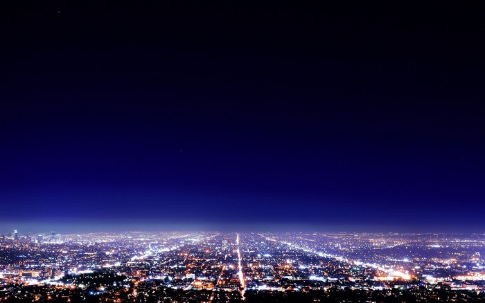 Night cityscape with glowing lights and dark sky
