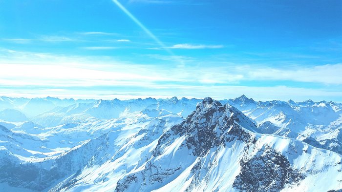 Snowy mountain range under a bright blue sky