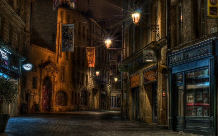 Empty European street at night with streetlights and banners