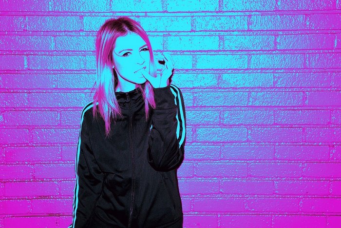 Woman with pink hair in a black tracksuit
