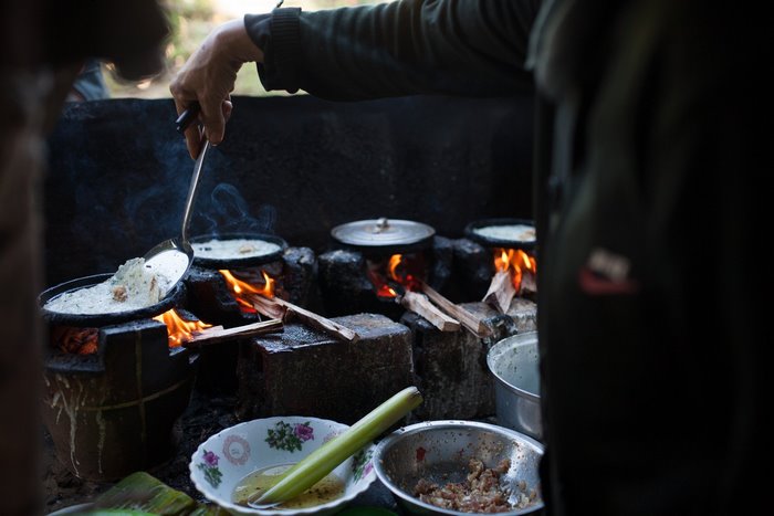 Person cooking food over an open fire
